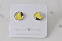 Round stud earrings with yellow, black and cream geometric triangle design on card