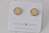 Round stud earrings with pink, yellow and teal triangle mosaic pattern on white card