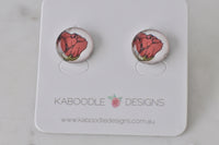 Round stud earrings with hand-drawn coral rose artwork under glossy dome, on Kaboodle card