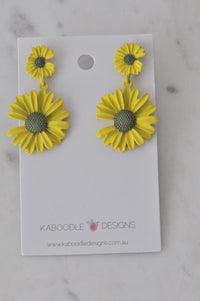 Pair of yellow daisy stud dangle earrings on Kaboodle Designs card, front view