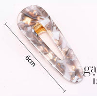 Teal and pink swirl barrette clip with 6cm measurement marked against grey tortoiseshell design