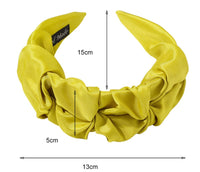 Black ruched headband viewed from above showing the gathered fabric folds