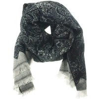 Black and grey lace-print winter scarf draped and knotted, showing fringed ends