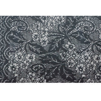 Close-up of the scarf's black and white lace-style jacquard pattern