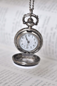Open pocket watch necklace showing white watch face with Quartz movement and black numerals