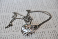 Alice in Wonderland pocket watch necklace closed and resting on chain