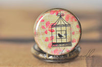 Close-up of the birdcage and bird pendant design with pink autumn leaves and script background