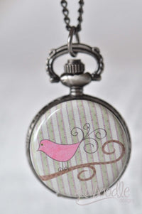 Pink bird pocket watch necklace with striped background, hanging closed