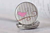 Close-up of pink bird on branch design on pocket watch pendant