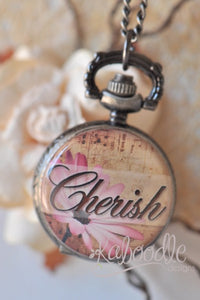 Pocket watch necklace with 'Cherish' script and pink daisy design on antiqued case