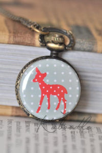 Antique bronze pocket watch necklace featuring a red polka dot deer design on a grey background