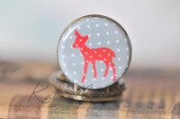 Close-up of the red polka dot deer pocket watch pendant resting on the closed watch case