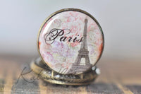 Close-up of the Paris Eiffel Tower pocket watch pendant design with pink floral background