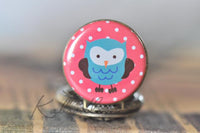 Close-up of owl design on pink polka dot pocket watch pendant lid