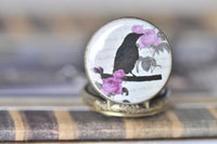 Close up of the bird and rose pattern on the pocket watch pendant