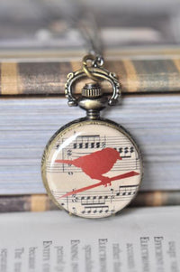 Antique brass pocket watch necklace with a red bird on vintage sheet music design