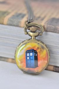 Antique brass pocket watch necklace featuring a blue police box design on a galaxy background