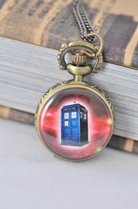Small brass pocket watch necklace featuring a blue police box against a starry red galaxy background