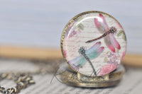 Close-up of dragonfly and rose design on pocket watch pendant
