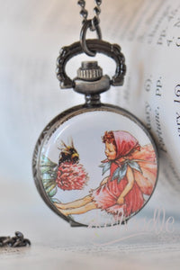 Pocket watch necklace featuring a fairy in pink greeting a bumblebee on a clover flower