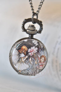 Pocket watch necklace pendant showing two illustrated fairy sisters among dark garden foliage