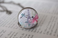 Close up of Eiffel Tower and dragonfly pendant design on pocket watch necklace