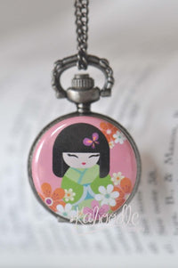Japanese kokeshi doll pocket watch necklace with pink floral background