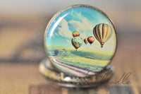 Close-up of hot air balloon scene on antique bronze pocket watch pendant