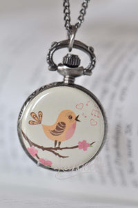 Singing bird pocket watch necklace with floral branch design and pink hearts
