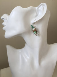 Close-up of frappe earring worn on ear showing green straw and cream detail