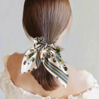 Mustard polkadot scrunchie tied in a bow on a model's ponytail, back view