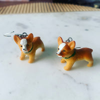 Corgi earrings laid flat on marble surface showing full dog shape and stainless steel hooks