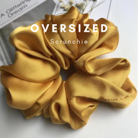 Mustard yellow oversized scrunchie with glossy folds, flat lay view