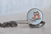 Close-up of owl and branch design on round bronze pocket watch pendant