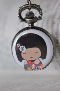Close-up of kawaii Japanese doll pocket watch necklace with floral kimono design