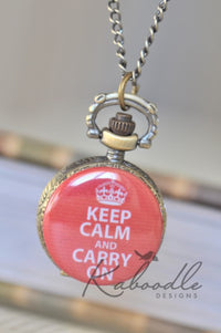 Red Keep Calm and Carry On pocket watch necklace with crown design, hanging closed on chain