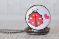 Close-up of ladybird and heart design on pocket watch pendant, unattached to chain