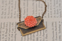 Closed envelope necklace with coral flower charm on the front flap