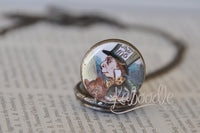 Close-up of Mad Hatter illustration on pocket watch necklace pendant