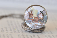 Close-up of the Mad Hatter tea party illustration on the pocket watch pendant lid