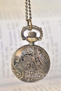 Close-up of ornate floral and scroll engraving on the pocket watch back cover