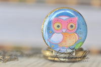 Painted owl pocket watch pendant resting closed showing full artwork detail