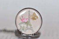 Close-up of the Paris-themed pocket watch pendant showing Eiffel Tower and fleur de lis detail