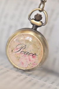 Closed pocket watch necklace with 'Peace' script over pink roses and vintage postmark design