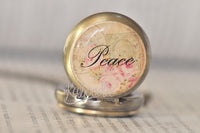 Close-up of the 'Peace' pocket watch pendant glass dome with floral vintage artwork