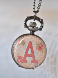 Shabby pink rose initial pocket watch necklace with coral letter A on polka dot background