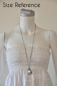 Pocket watch necklace shown on mannequin for size reference against white dress