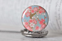 Close-up of cherry blossom glass dome design on pocket watch pendant
