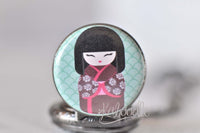 Close up of kokeshi doll illustration inside glass dome pocket watch pendant