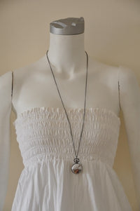 White Rabbit pocket watch necklace displayed on a mannequin wearing a white dress